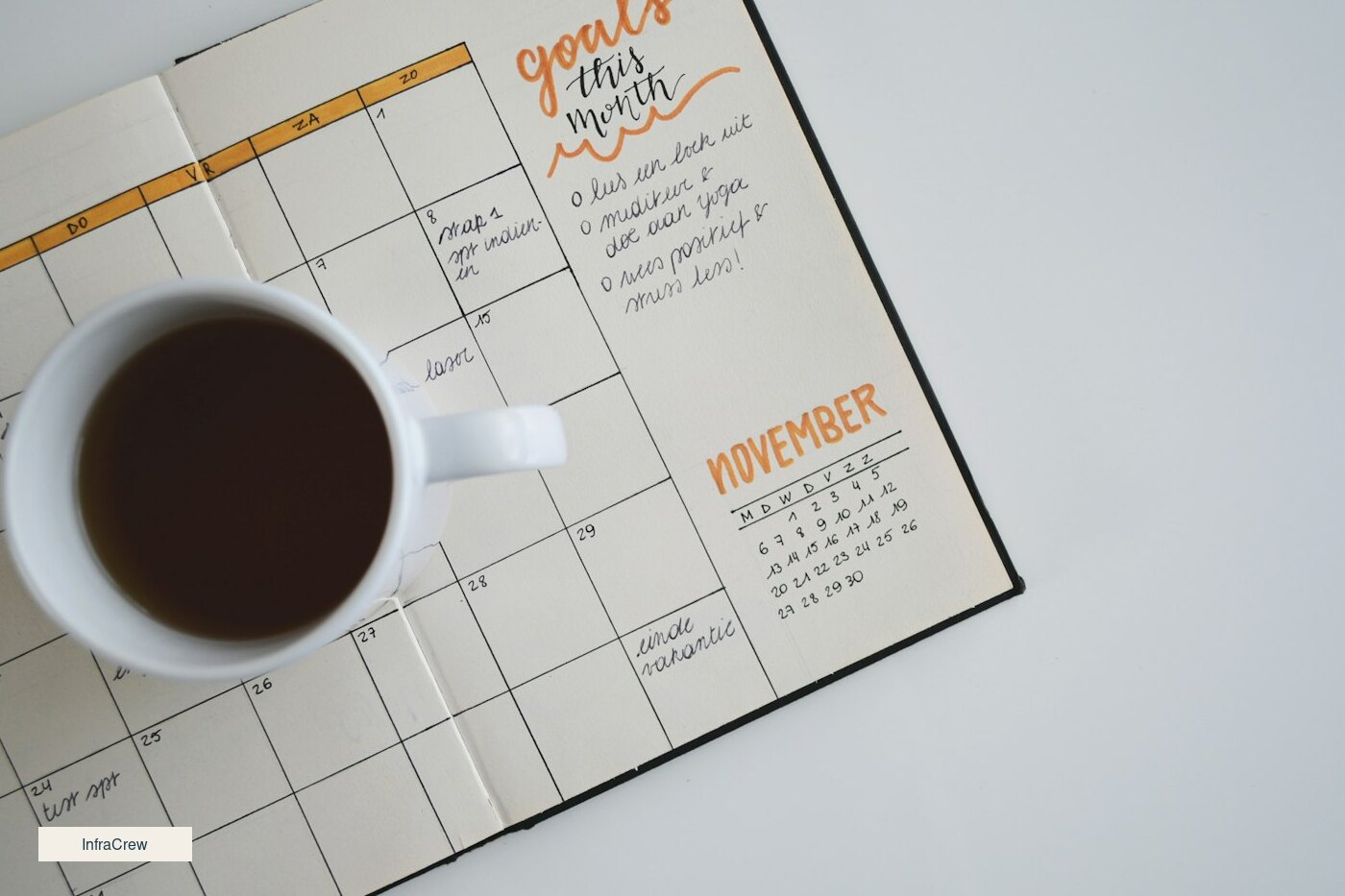 Calendario de octubre sobre una mesa de madera con un café, y una tarjeta clara de InfraCrew en la esquina, como el plazo del 11.